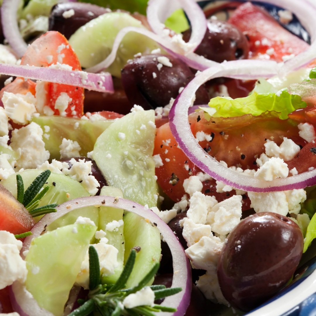 gemischter salat mit oliven, tomaten, gurken und zwiebeln. essig, öl und gewürze.